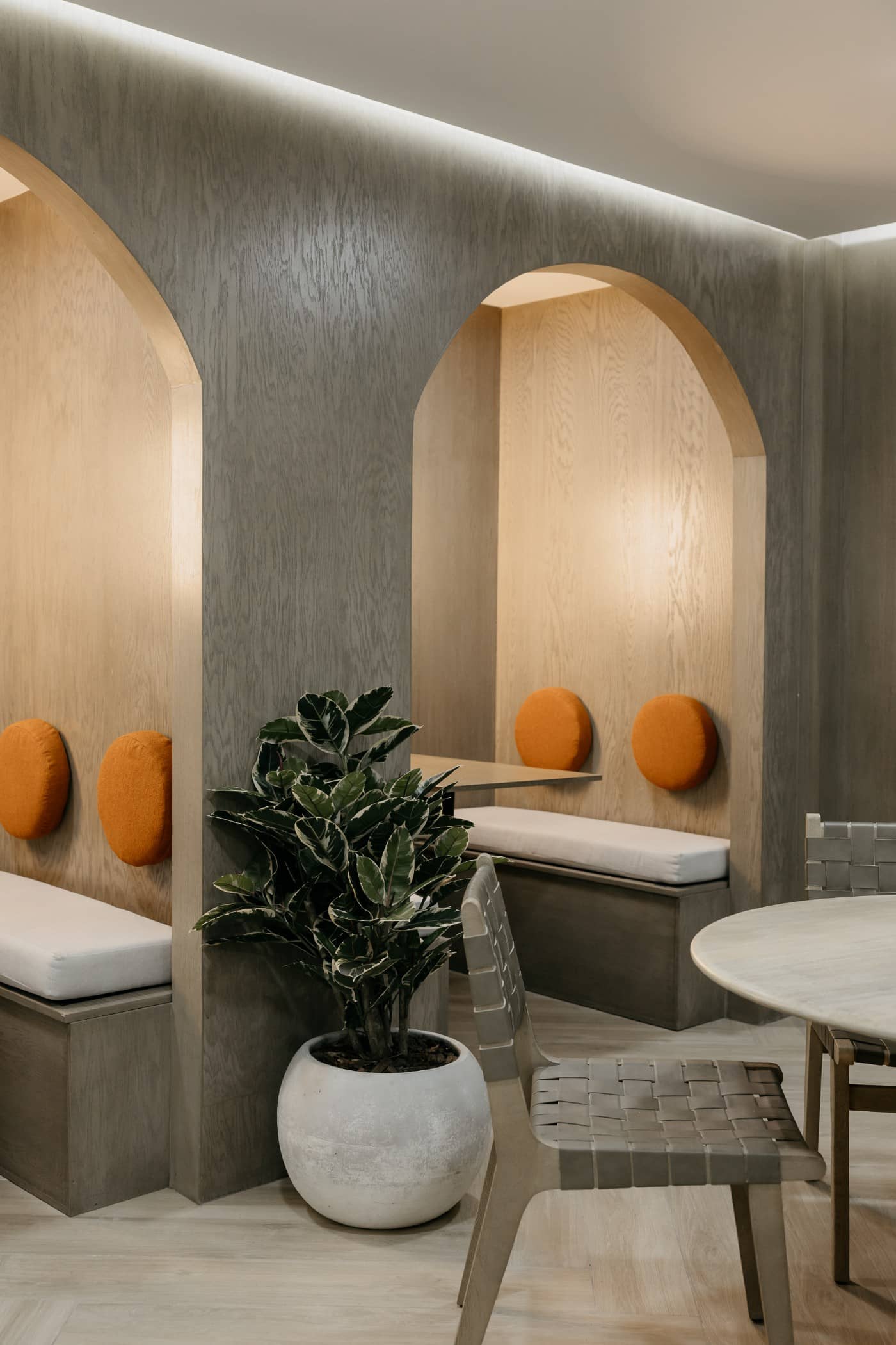 Comedor con nichos arqueados y cojines naranjas